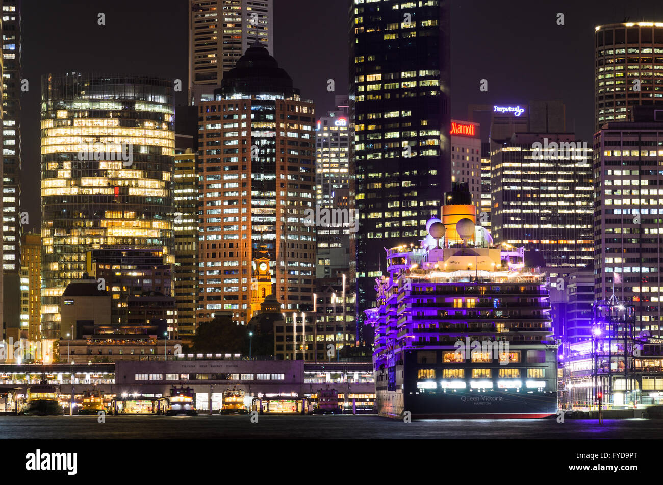 Il Circular Quay di Sydney durante la notte con una nave da crociera ancorata. Foto Stock