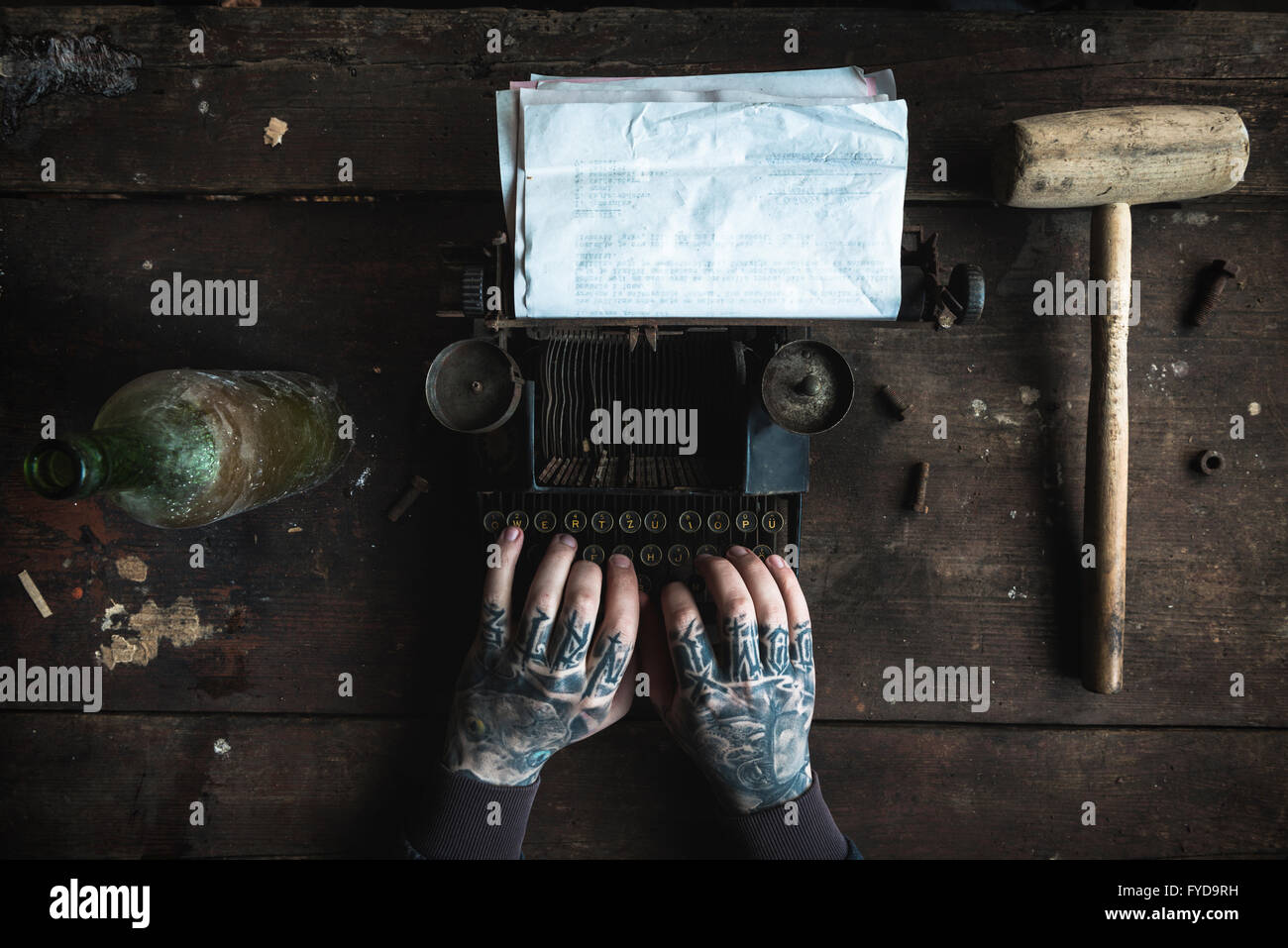 Scrittore con tatuata la scrittura a mano su una vecchia macchina di digitazione con carta bianca,fuoco selettivo Foto Stock