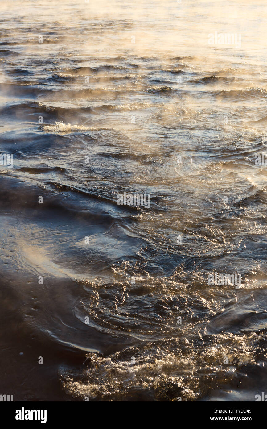 Il vapore acqueo sulla superficie del freddo acqua ghiacciata a sunny fredda giornata invernale Foto Stock