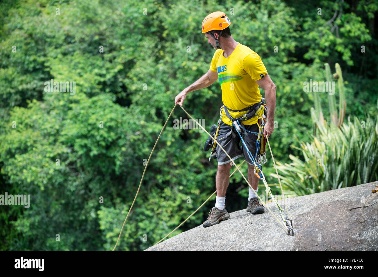 RIO DE JANEIRO - Marzo 5, 2016: Un rocciatore si erge con funi di sicurezza pronto a scendere il Morro da Urca a Sugarloaf Mountain Foto Stock