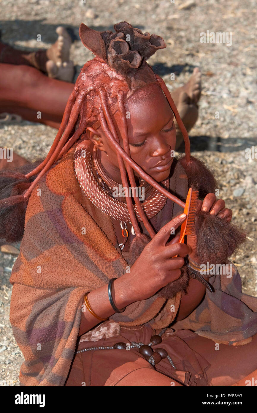 Gli Himba sono un popolo nomade della Namibia. Essi ornarsi con collari in pelle e anelli di ottone e rivestire la loro pelle con una pasta a base di burro e legno rosso. Le ragazze indossano due trecce spessa, intrecciato faccia in avanti e raddrizzare sopra la fronte come le corna, Namibi Foto Stock