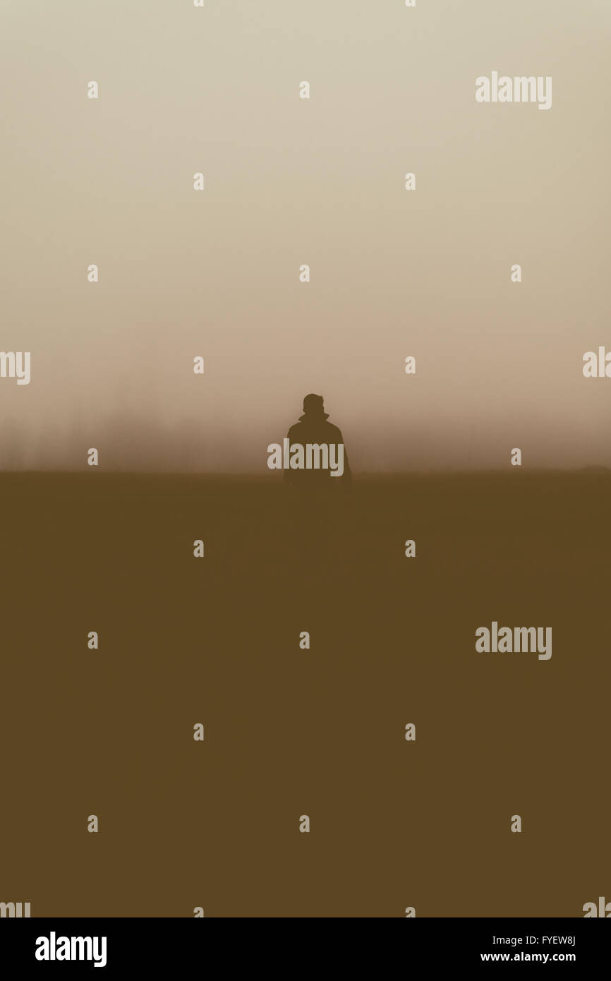Silhouette della persona che cammina nella nebbia. Foto Stock