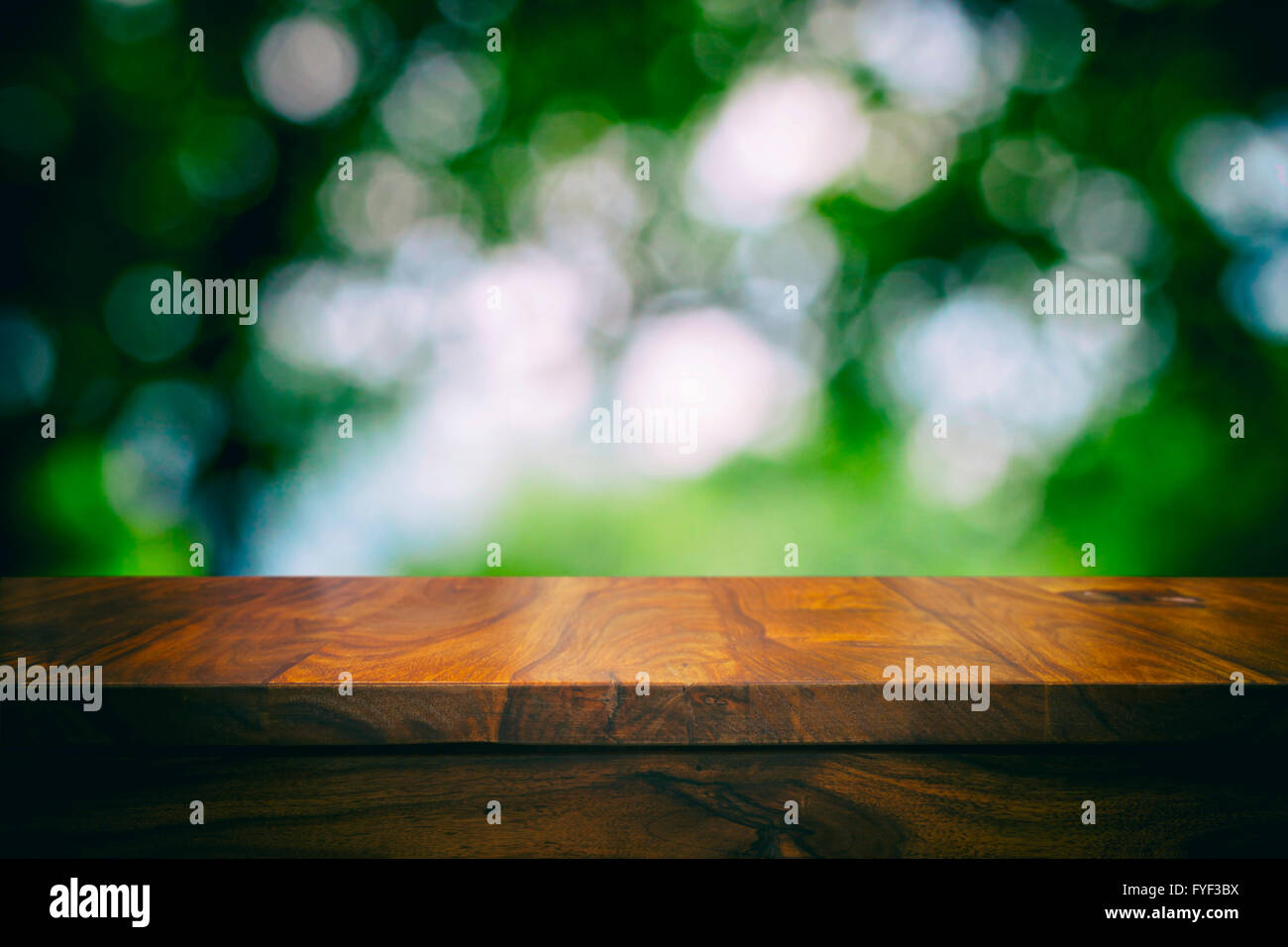 Svuotare la parte superiore del tavolo in legno e motivi floreali sfondo sfocato Foto Stock