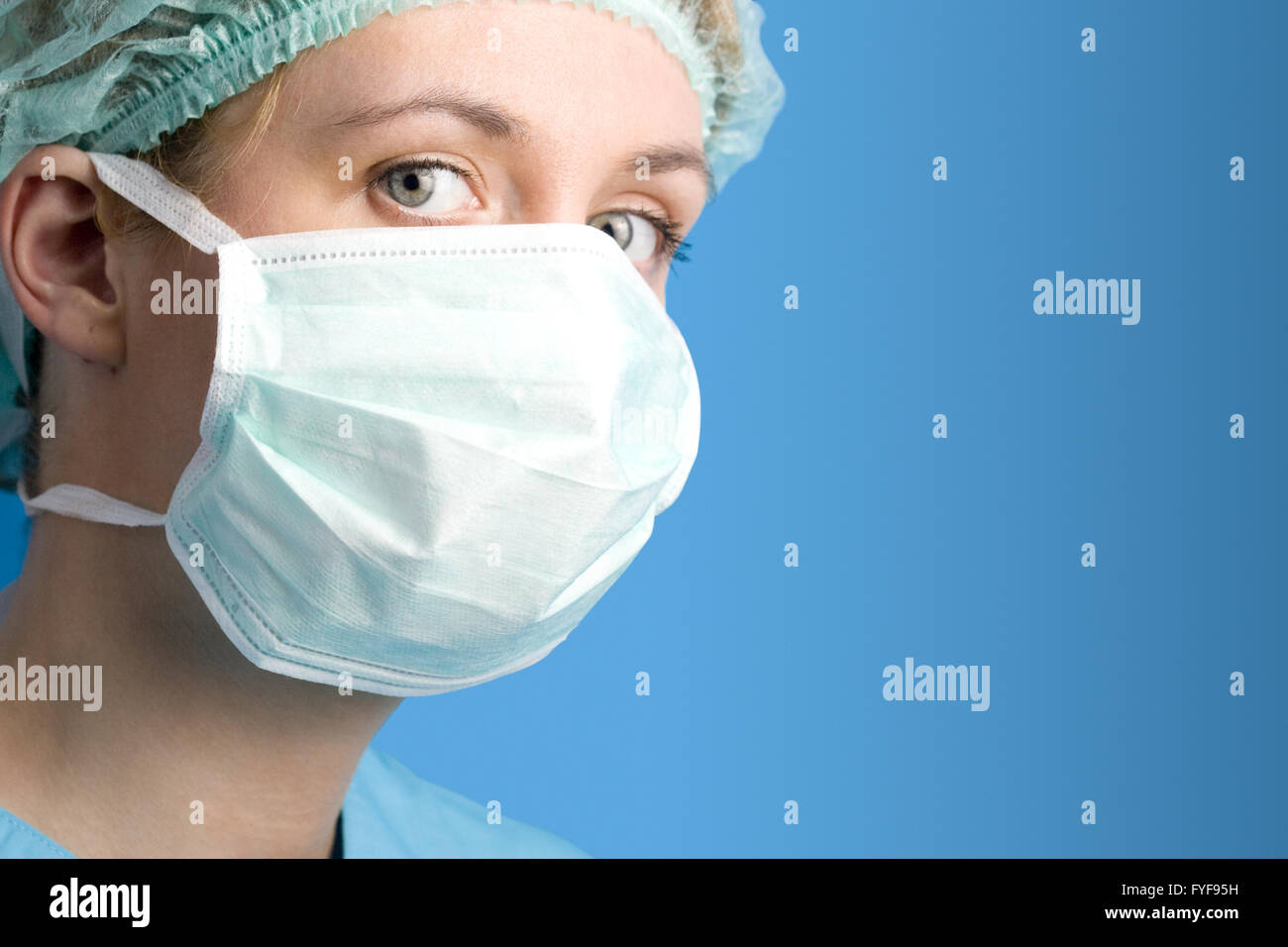 Posizione orizzontale ritratto di una giovane donna con gli occhi blu che indossa un dispositivo chirurgico per la maschera bianca Foto Stock