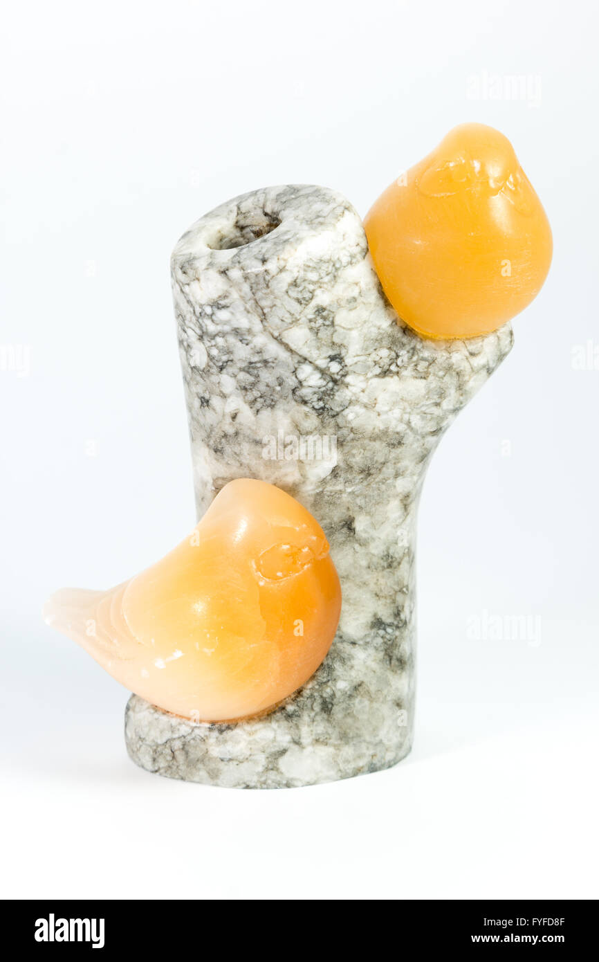 Due uccelli ambra su una struttura di granito su sfondo bianco Foto Stock