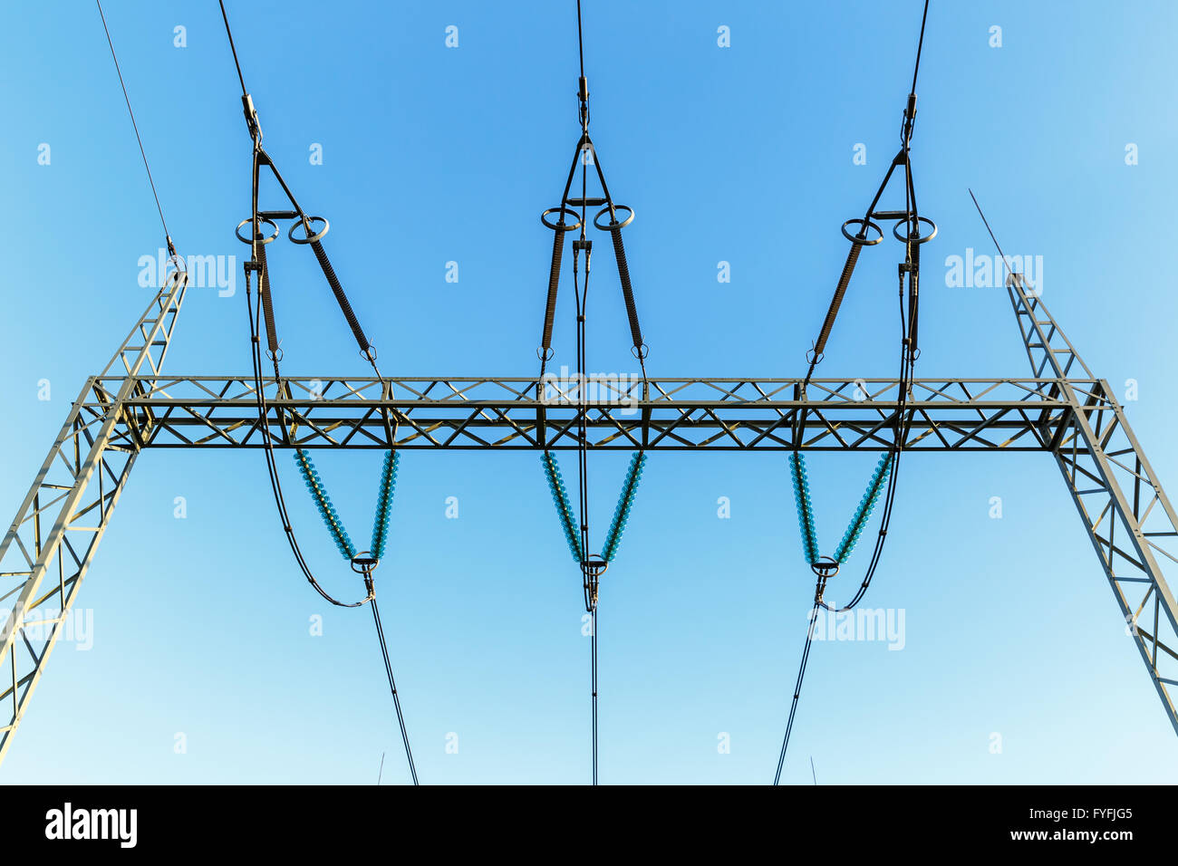 Di elettricità ad alta tensione tralicci contro il cielo blu Foto Stock