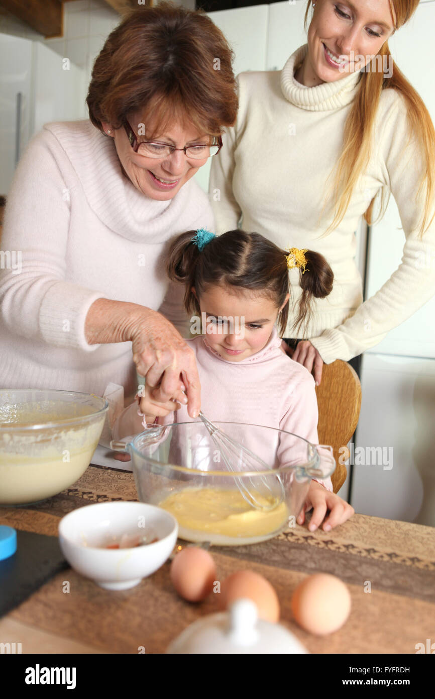 Nonna rendendo le crepes con piccolo nipote Foto Stock