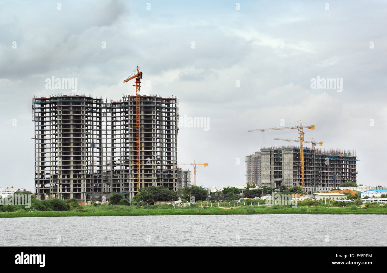 Alto edificio di costruzione mediante gru a torre e altre attrezzature da costruzione Foto Stock