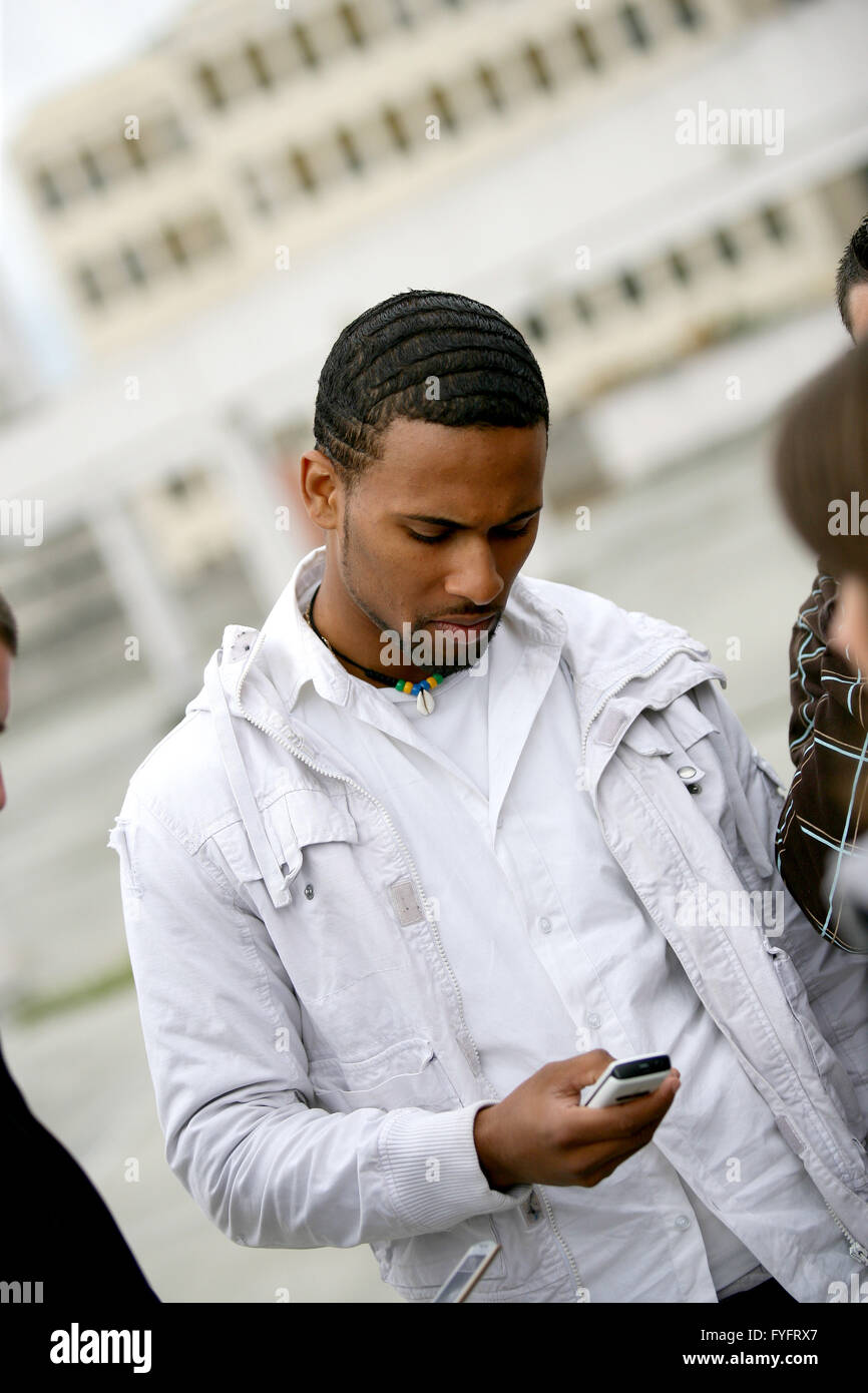 Uomo di afro-americana di inviare un messaggio di testo sul telefono Foto Stock