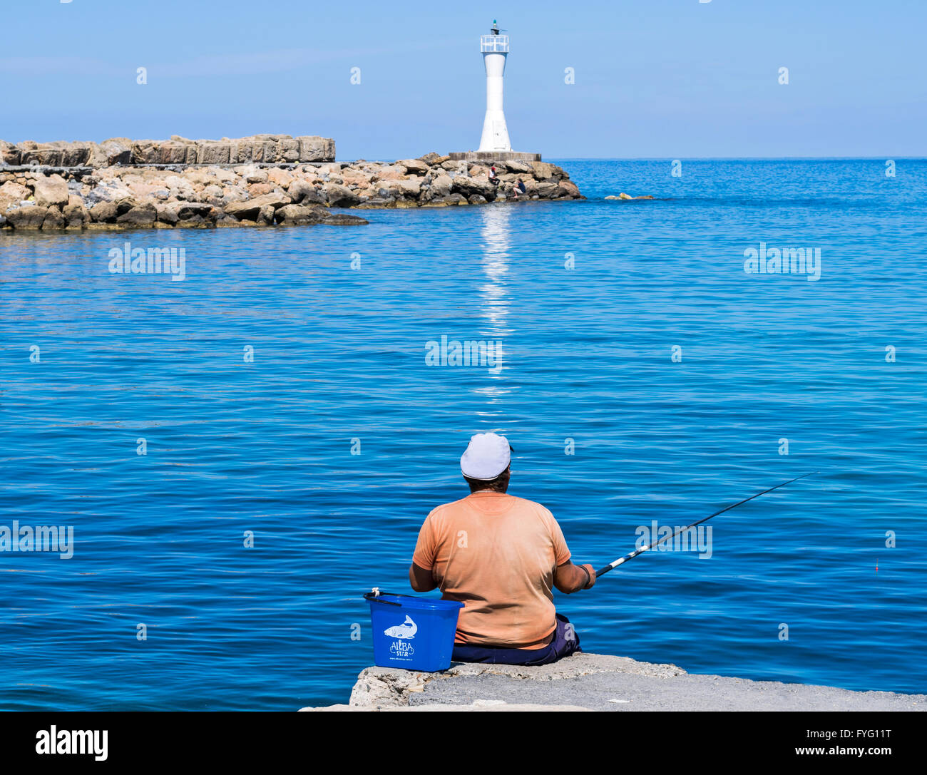 Cipro Nord KYRENIA pescatore in arancione sul muro del porto Foto Stock