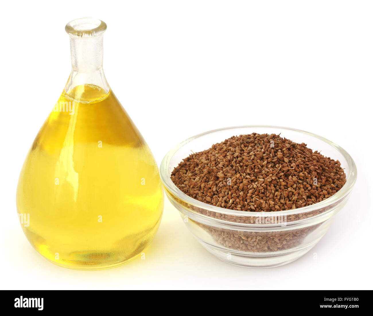 Semi di Ajwain in una ciotola di vetro con olio essenziale su sfondo bianco Foto Stock