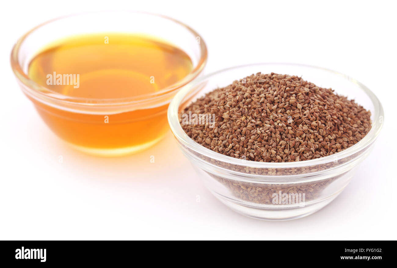 Semi di Ajwain in una ciotola di vetro con olio essenziale su sfondo bianco Foto Stock
