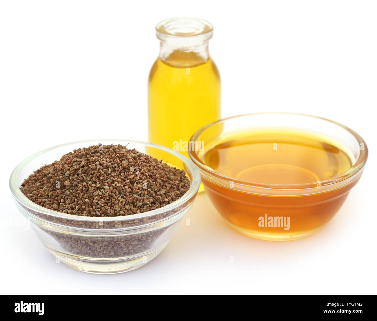 Semi di Ajwain in una ciotola di vetro con olio essenziale su sfondo bianco Foto Stock