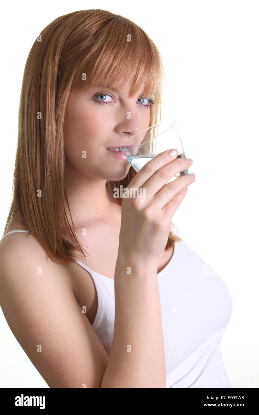 Splendida donna di zenzero di bere un bicchiere di acqua Foto Stock