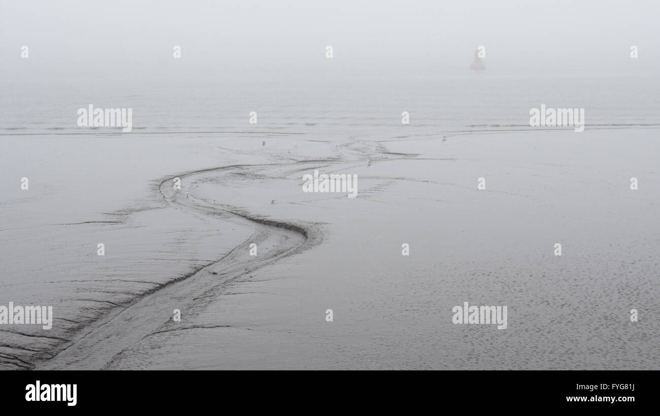 Il fango è esposto sul fiume Mersey estuario a bassa marea a Liverpool durante un inverno di nebbia. Birkenhead, solitamente visibili attraverso la Foto Stock