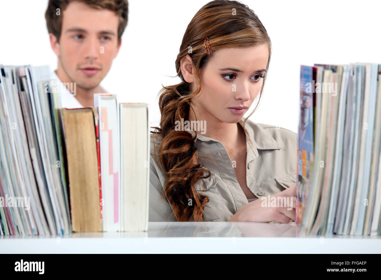 Giovane donna in biblioteca pubblica e guy in background Foto Stock