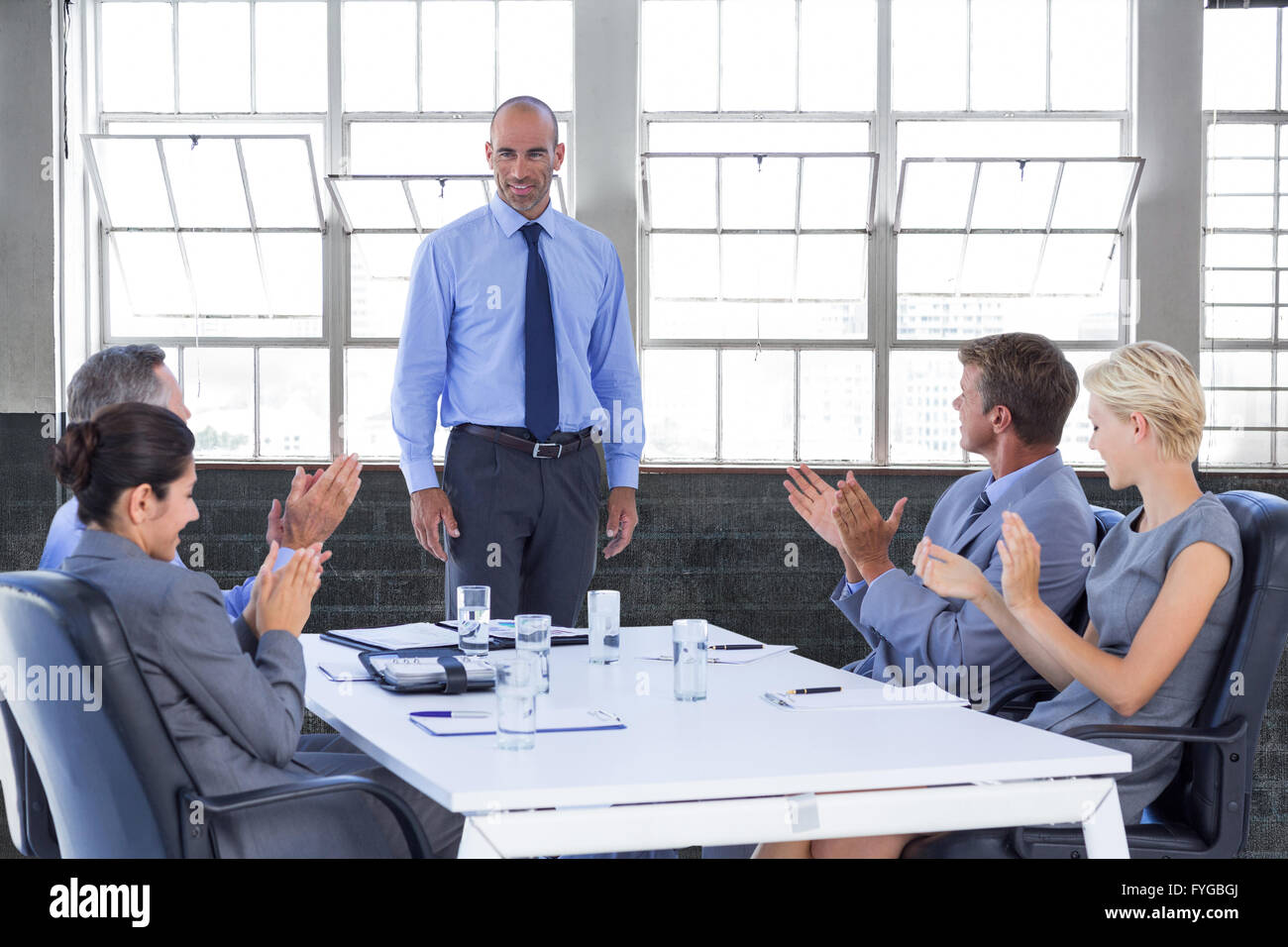 Immagine composita della gente di affari ad applaudire durante la riunione Foto Stock