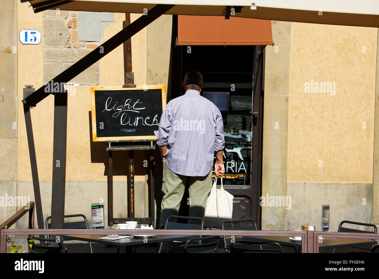 Uomo che guarda in un food bar finestra, Firenze, Italia Foto Stock