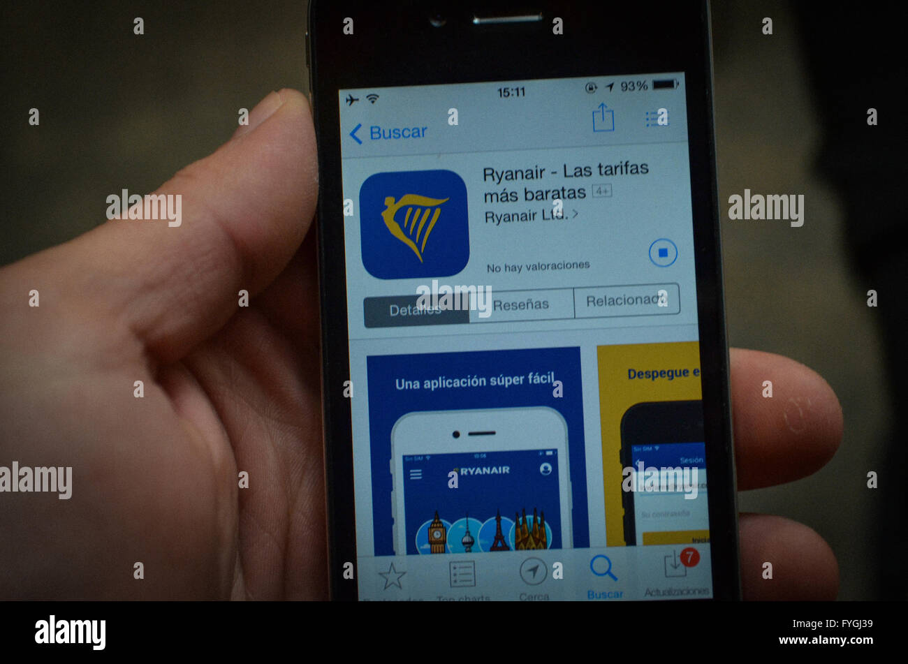 Uomo che guarda per la Ryanair app in Appstore attraverso il suo iPhone 4 Foto Stock