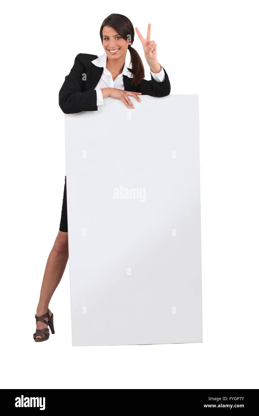Smart giovane dipendente che dà il segno di pace con una scheda vuota Foto Stock