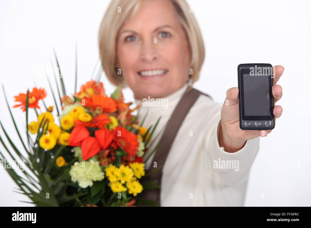 Anziani fioraio azienda fiori e telefono mobile Foto Stock