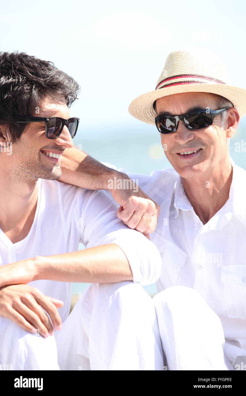 Padre e figlio crogiolarsi sotto il sole insieme Foto Stock