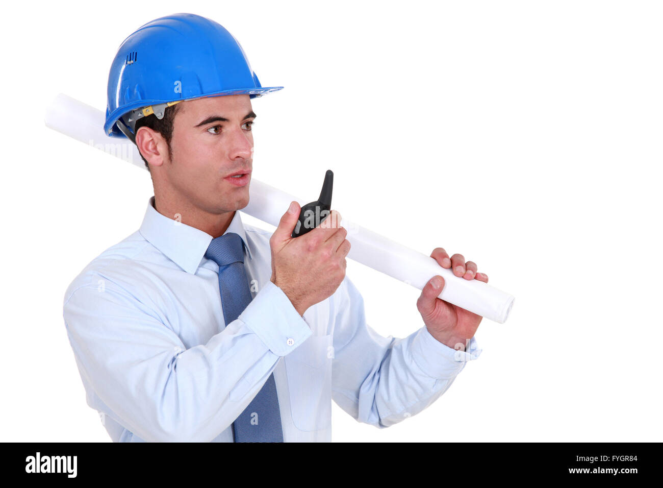 Ingegnere tenendo un arrotolamento a pianificare e parlando in un walkie-talkie Foto Stock