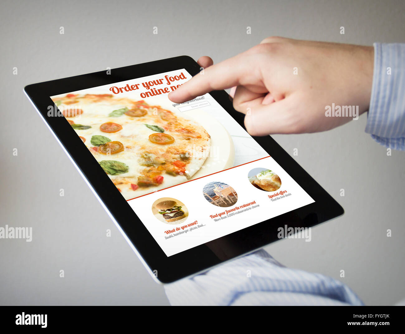 Le nuove tecnologie il concetto: mani con touchscreen tablet cibo di ordinazione online. Grafici dello schermo sono costituiti. Foto Stock