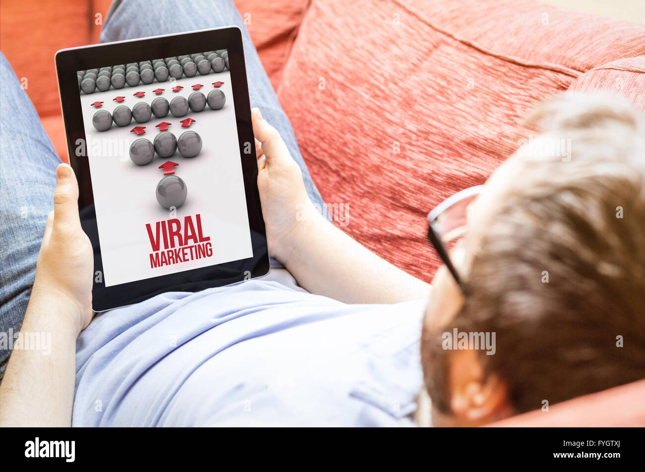 Tecnologia il concetto di stile di vita: hipster sul divano con il marketing virale tablet. Grafici dello schermo sono costituiti. Foto Stock