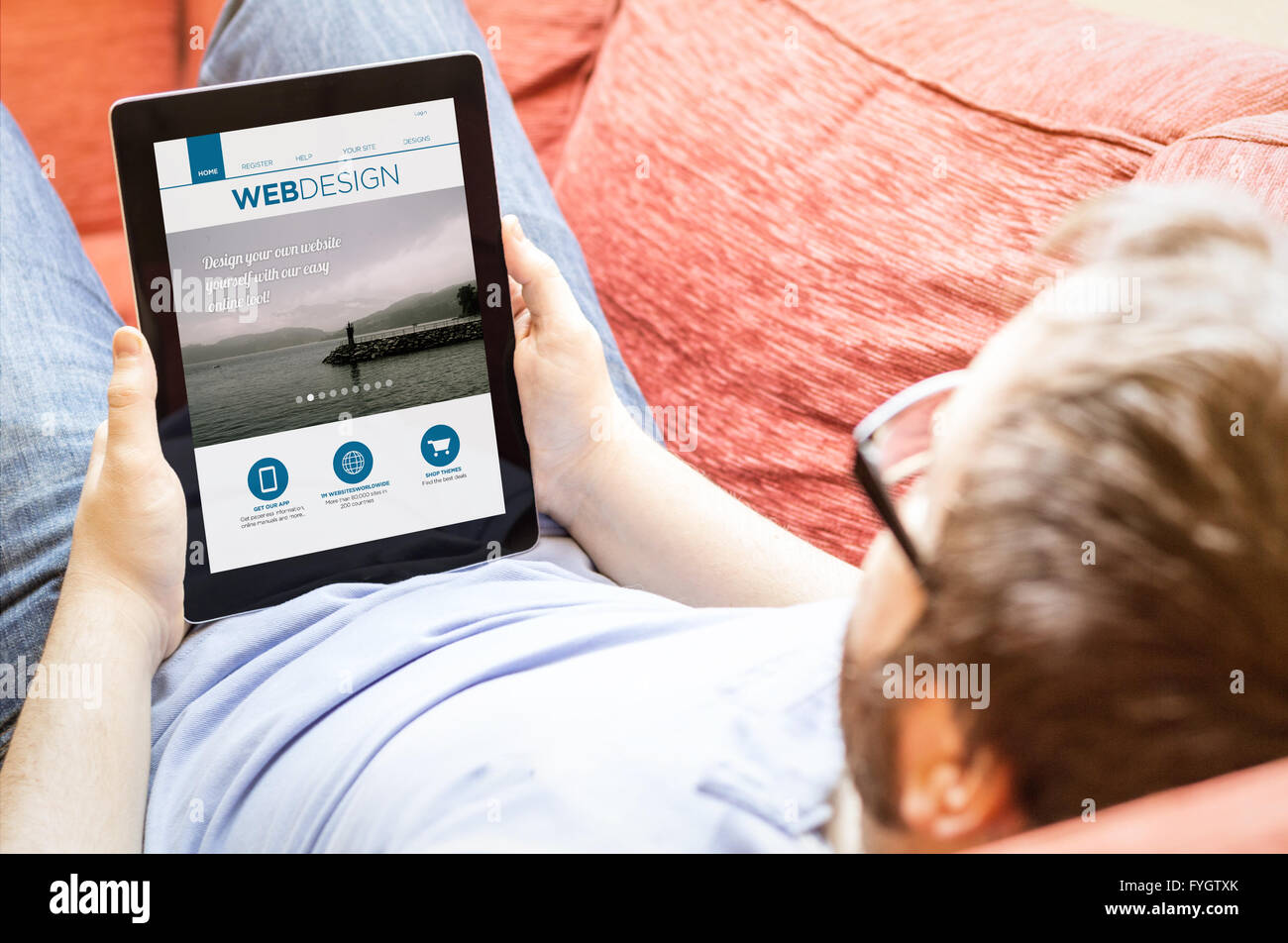 Tecnologia il concetto di stile di vita: hipster sul divano con la progettazione di un sito web su un tablet. Grafici dello schermo sono costituiti. Foto Stock