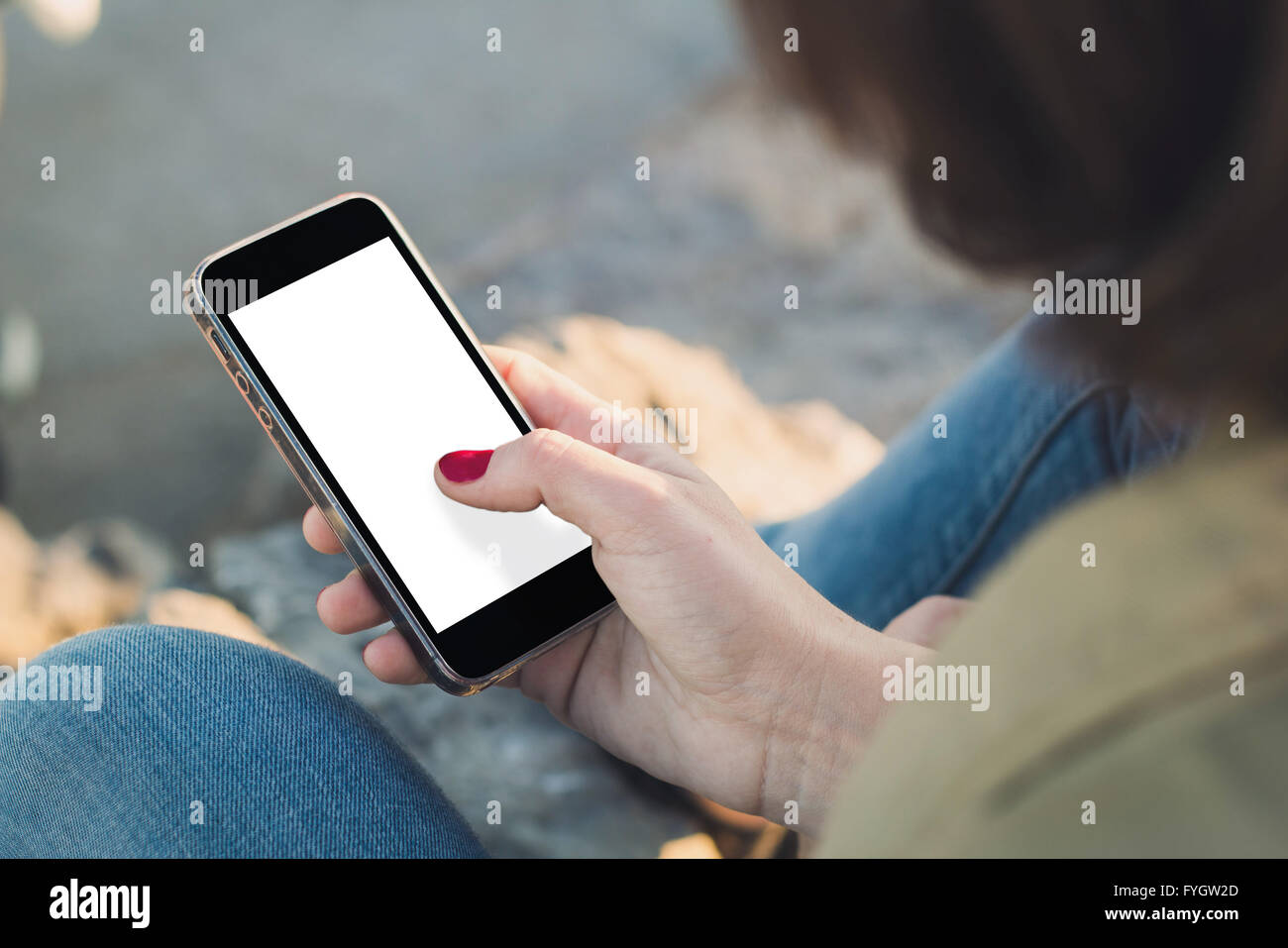 Donna che mantiene una schermata vuota smartphone e toccando lo schermo Foto Stock