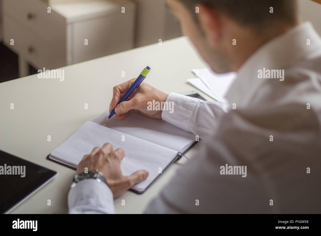 Imprenditore iscritto sul notebook in bianco Foto Stock