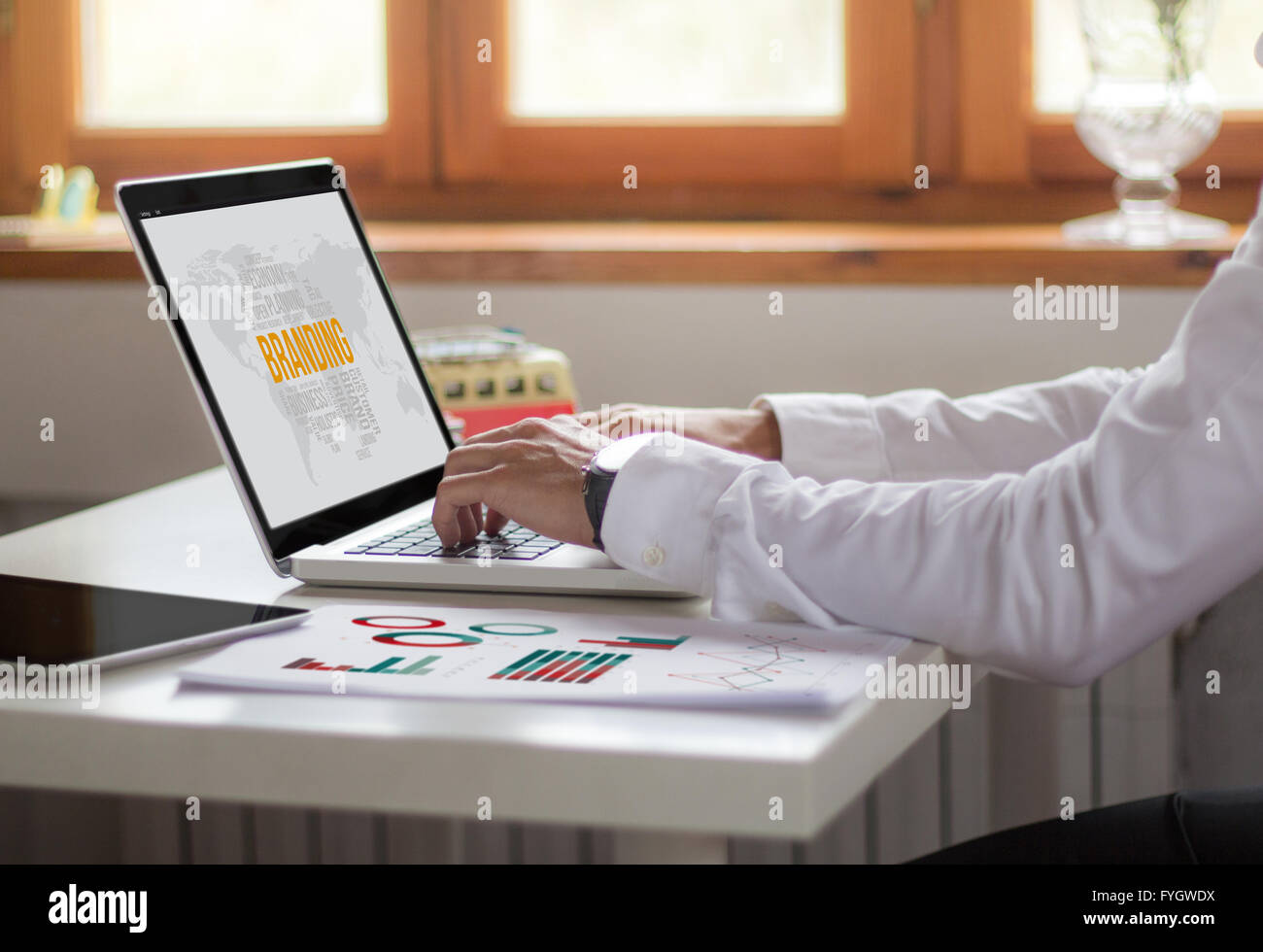 Imprenditore lavora con il portatile in ufficio. concetto di branding. Tutti i grafici dello schermo sono costituiti. Foto Stock