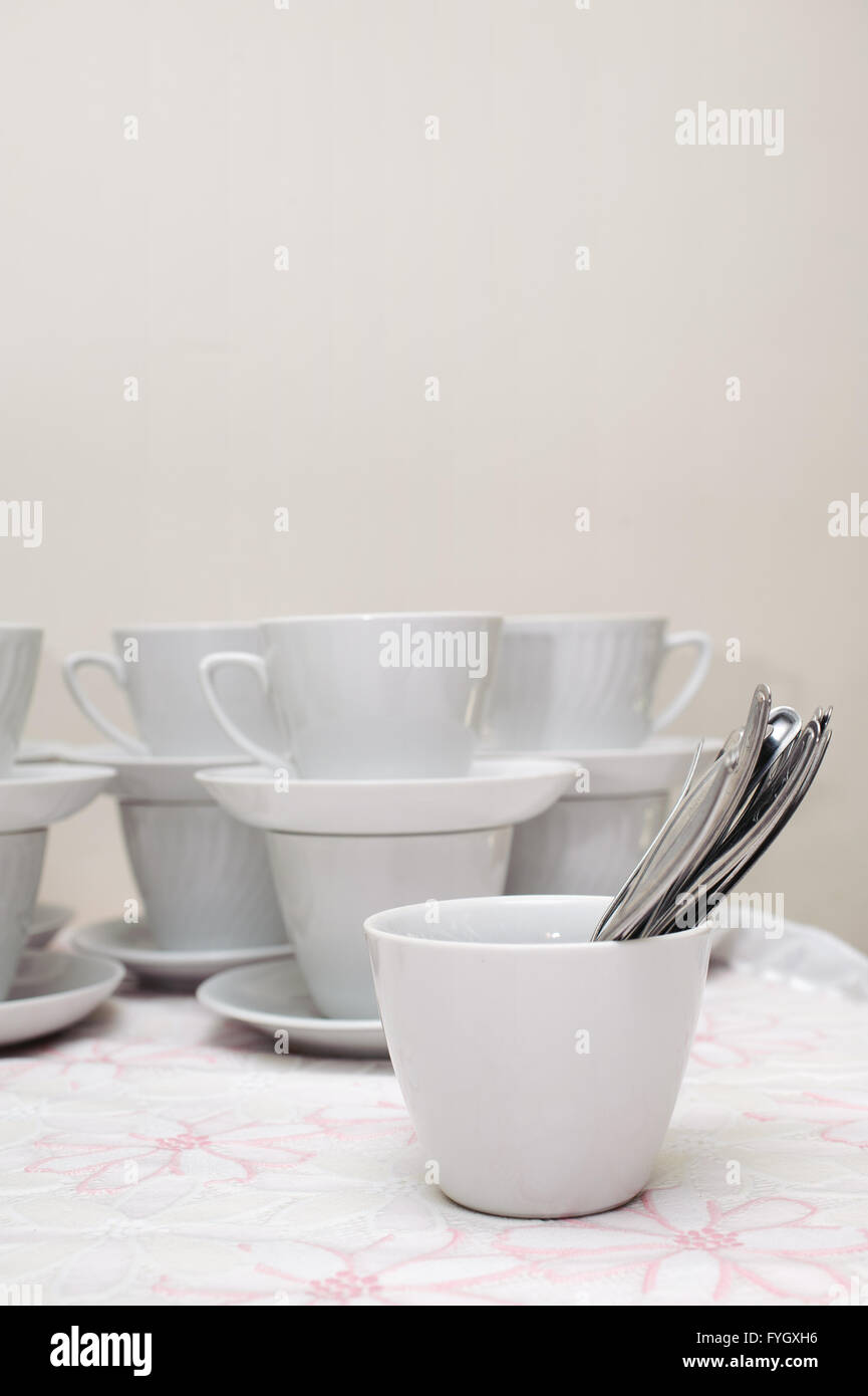 Molte tazze bianche con cucchiaio su un tavolo Foto Stock
