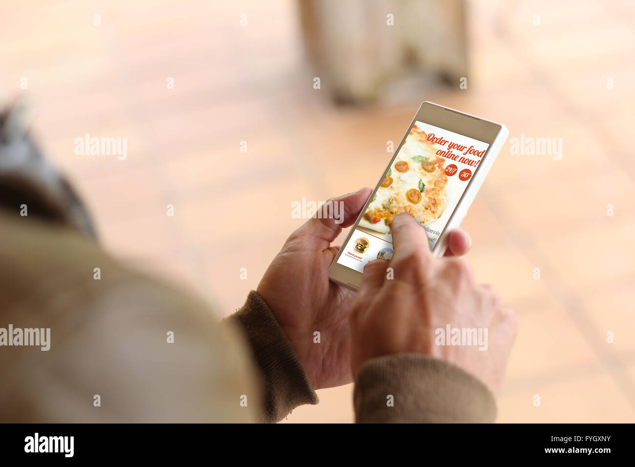 Uomo di toccare lo schermo del suo smartphone per ordinare cibo online. Tutti i grafici dello schermo sono costituiti. Foto Stock