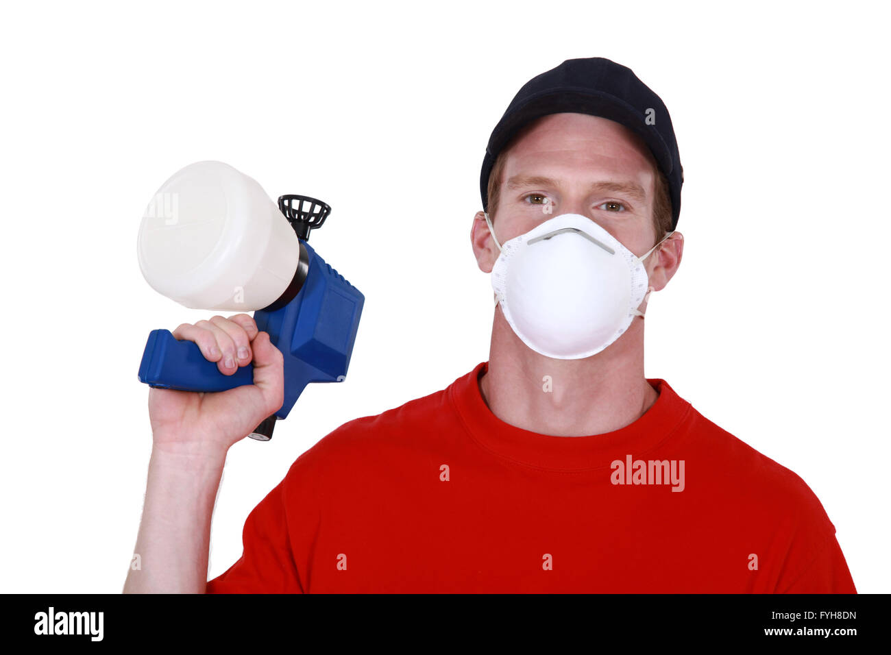 Tradesman in possesso di una pistola a spruzzo e indossare una maschera Foto Stock