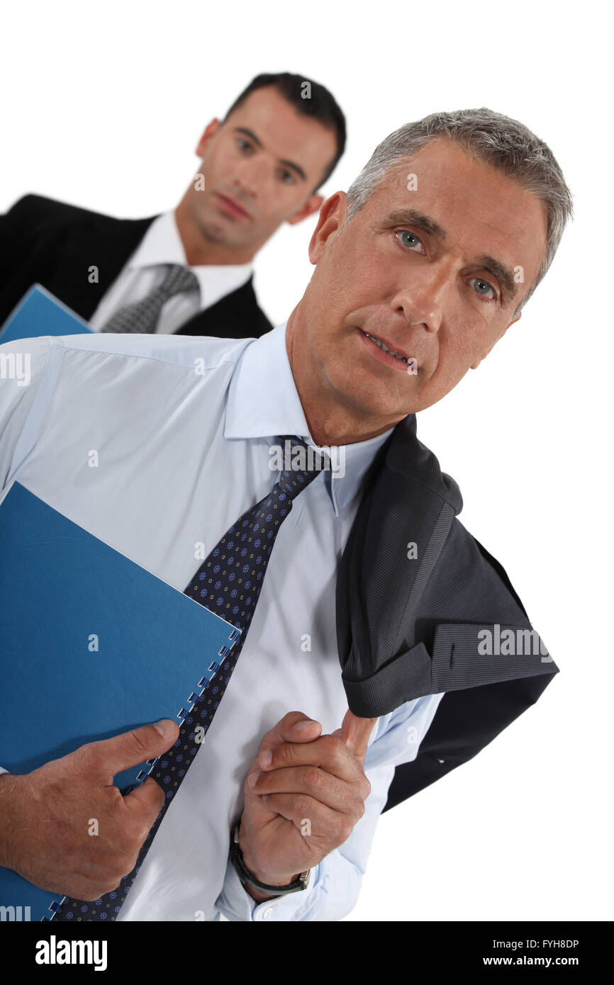 Ritratto di un imprenditore con il suo assistente arrancano dietro di lui Foto Stock