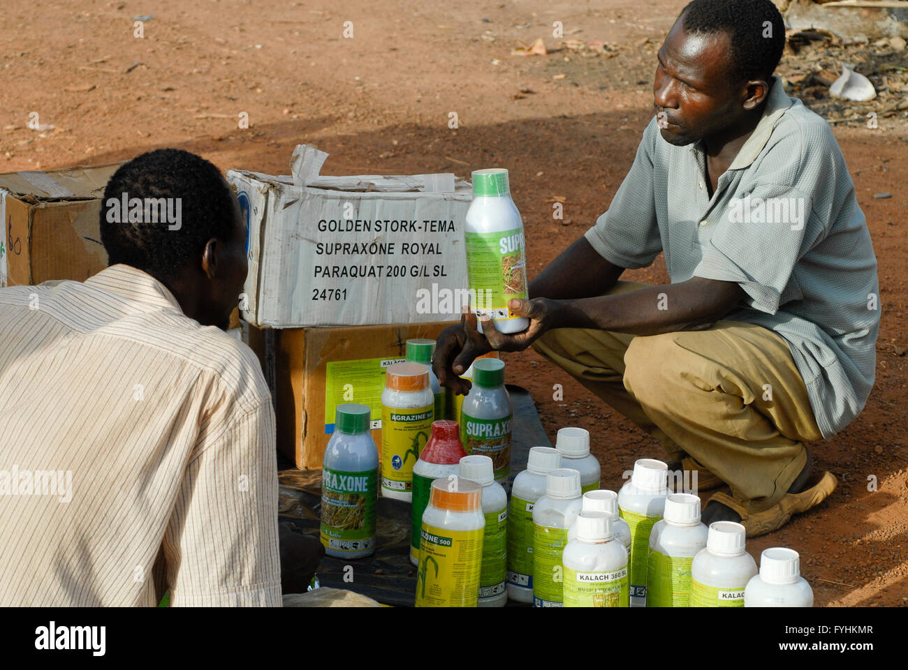 Il Burkina Faso, venditore ambulante vende pesticidi chimici per cotone e altre colture per agricoltore al Village market , imprenditore spesso non è in grado di leggere le istruzioni e il pericolo per la loro salute e l'ambiente con uso errato pesticida | [ copyright (c) Joe Foto Stock