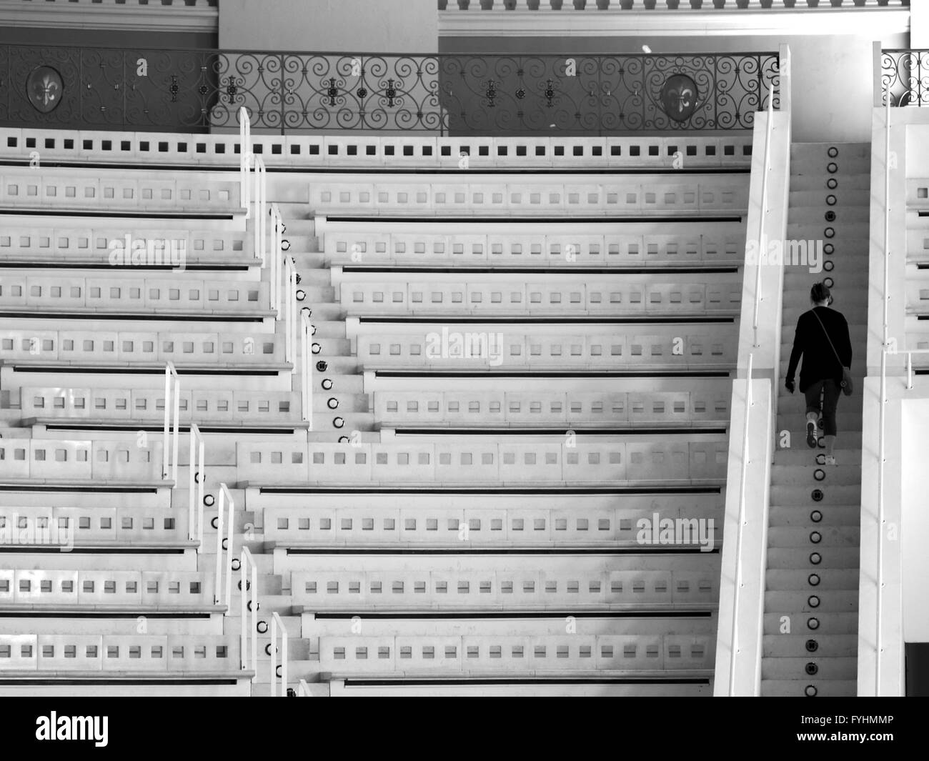 Donna salendo le scale in auditorium, in bianco e nero Foto Stock