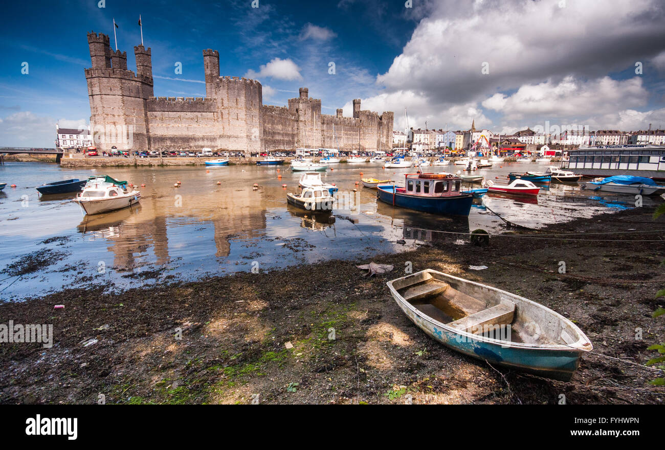 Il XIII secolo castello medievale riflesso nel fiume a Caernarfon in Galles del Nord, adesso sito del Patrimonio Mondiale. Foto Stock