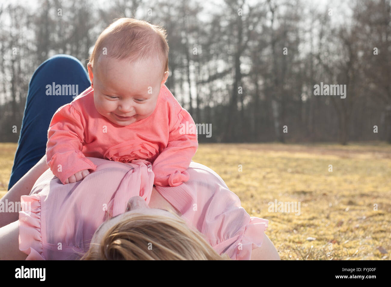 Il bambino si diverte a mamme di pancia Foto Stock