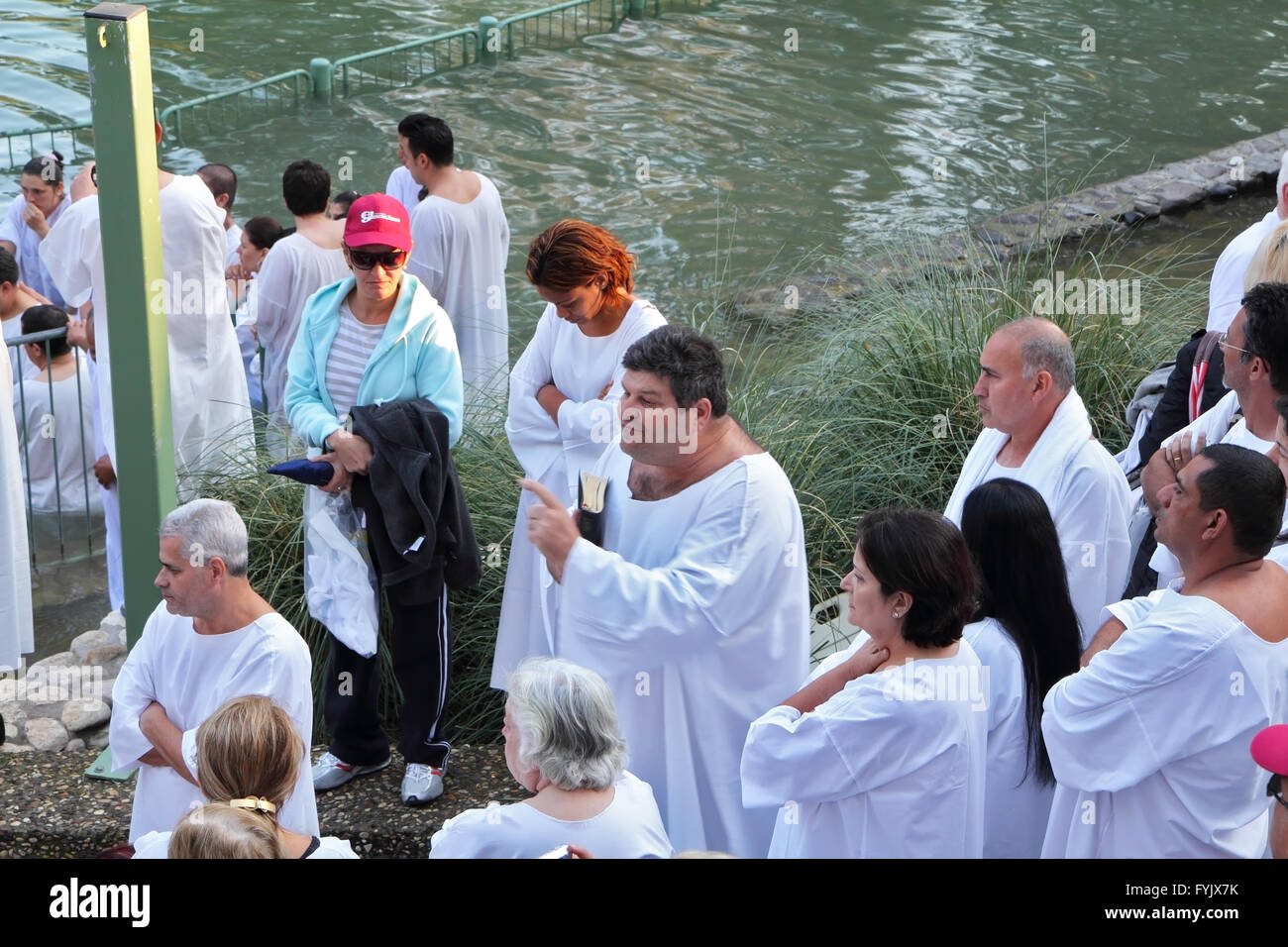 I pellegrini in attesa il suo turno in bianco maglietta di battesimo. Foto Stock
