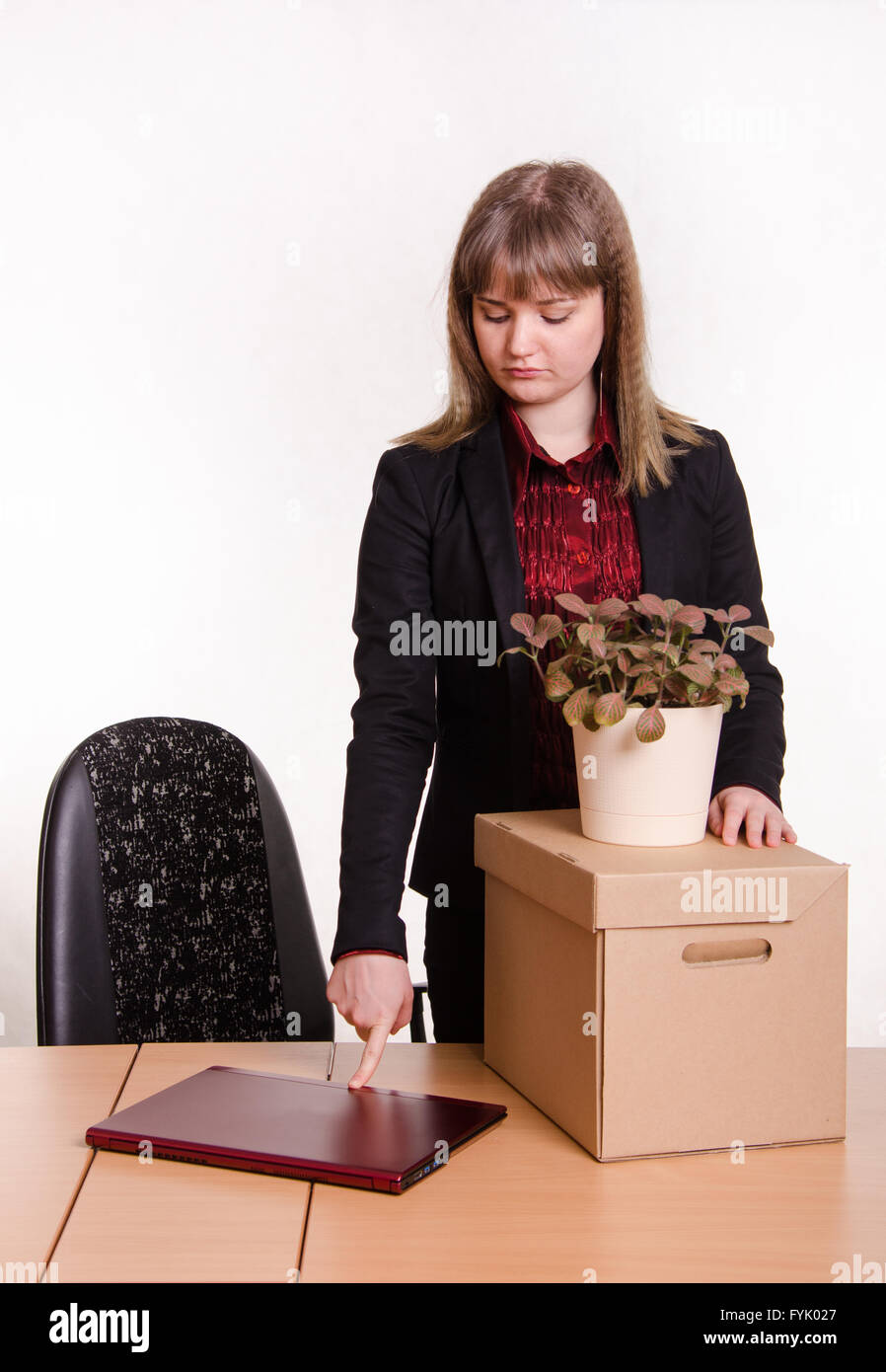Respinto ragazza in ufficio con computer portatile chiude le cose raccolte Foto Stock