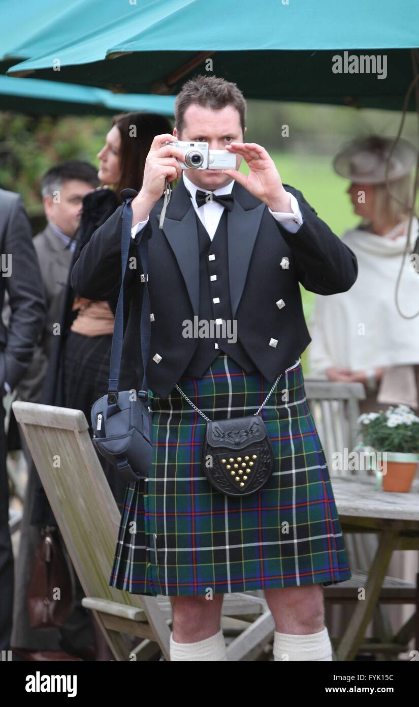 Un uomo che indossa un kilt scattare fotografie a un matrimonio con una fotocamera digitale compatta, Foto Stock