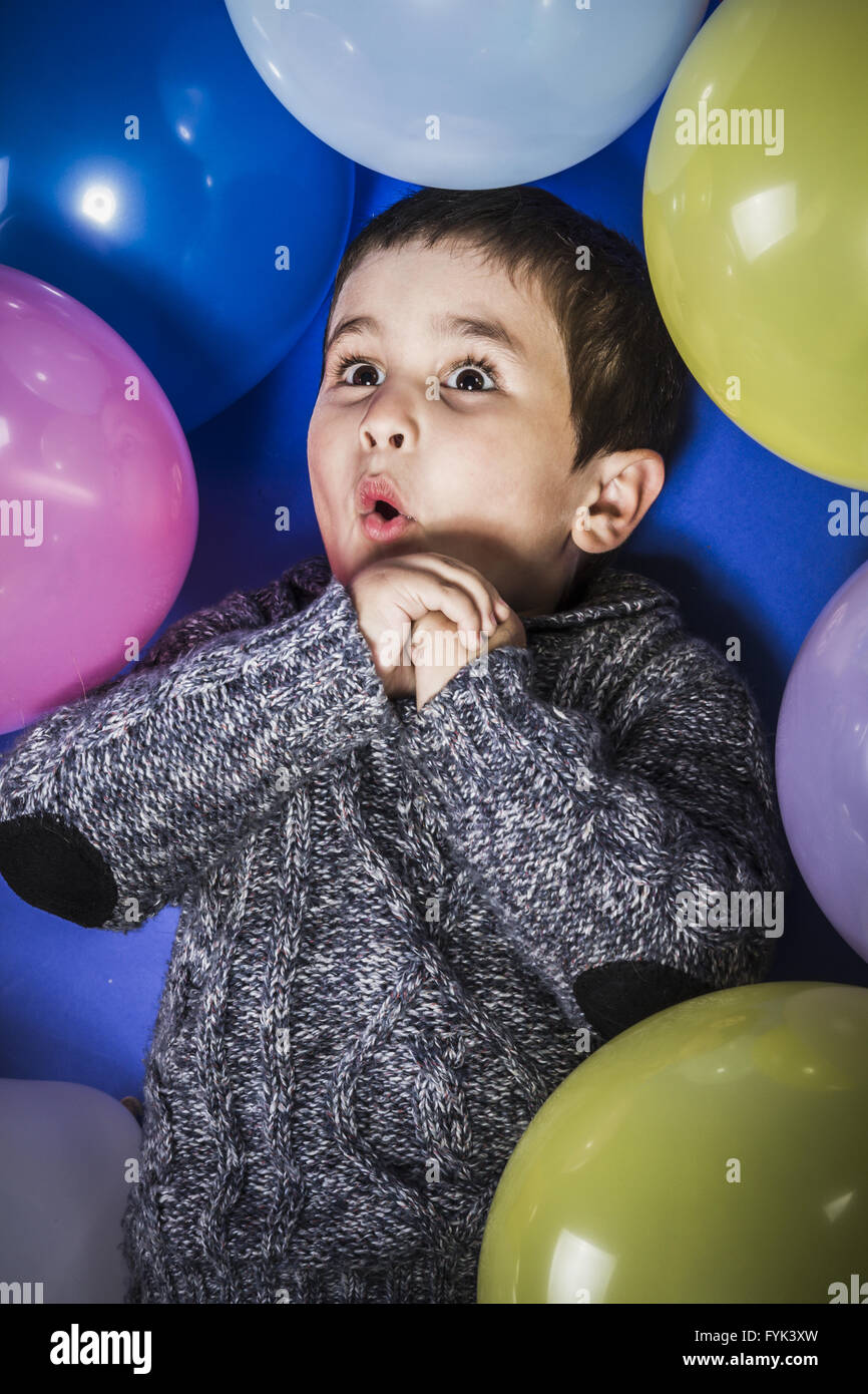 Ragazzo divertente giocare con palloncini di molti colori Foto Stock