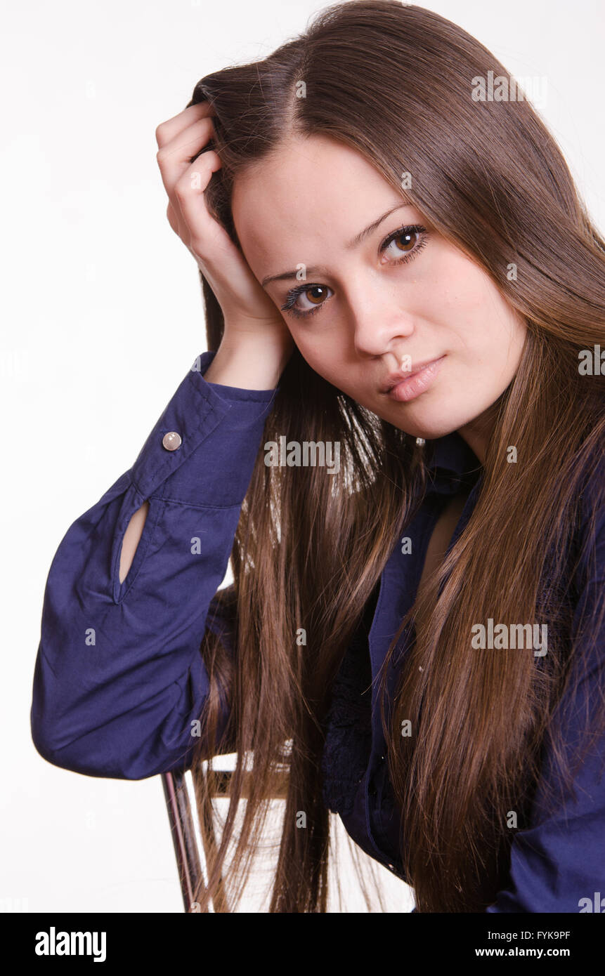 La ragazza con i capelli lunghi si appoggia la testa su un lato Foto Stock
