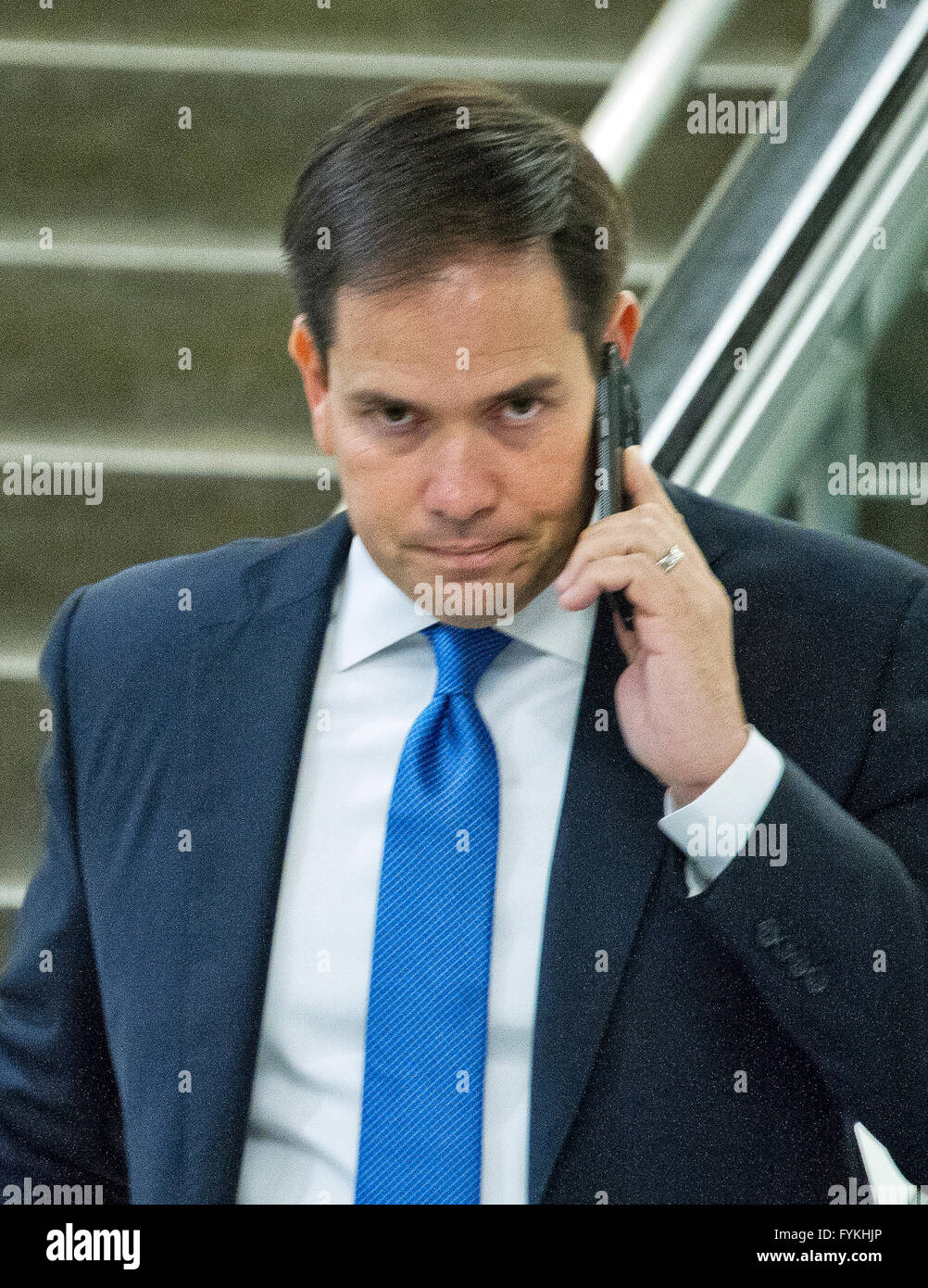Stati Uniti il senatore Marco Rubio (repubblicano della Florida) parla sul suo telefono cellulare come egli cammina per il treno in Campidoglio US alla metropolitana di Washington DC martedì 26 aprile, 2016. Credito: Ron Sachs/CNP - nessun filo SERVICE - Foto Stock