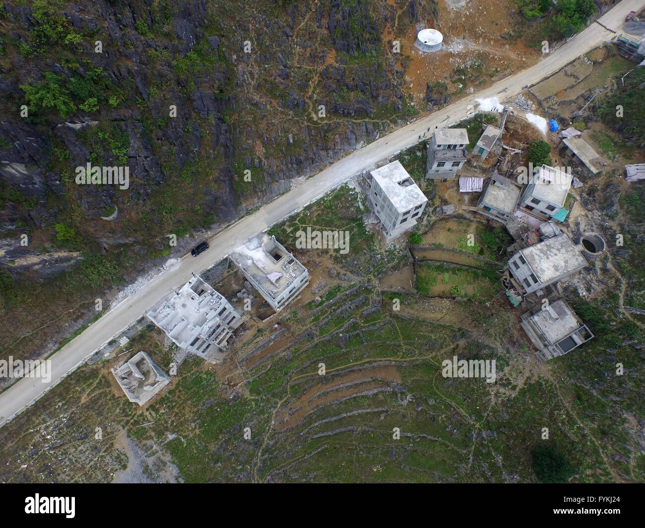 Dahua, Cina. Xxvii Aprile, 2016. Una foto aerea adottate il 28 marzo 2016 mostra gli edifici residenziali che sono costruiti su un 100-metro-profonda depressione Nonghe nel villaggio di Qibainong township di Dahua Yao contea autonoma, a sud della Cina di Guangxi Zhuang Regione autonoma. Qibainong città e città Bansheng, che hanno centinaia di depressioni con profondità media a 105 metri, individuare tra le montagne con altezza di 800-1000 m. Tuttavia, il pro capite di terra coltivata è inferiore a 0,25 um (0. Credito: Xinhua/Alamy Live News Foto Stock