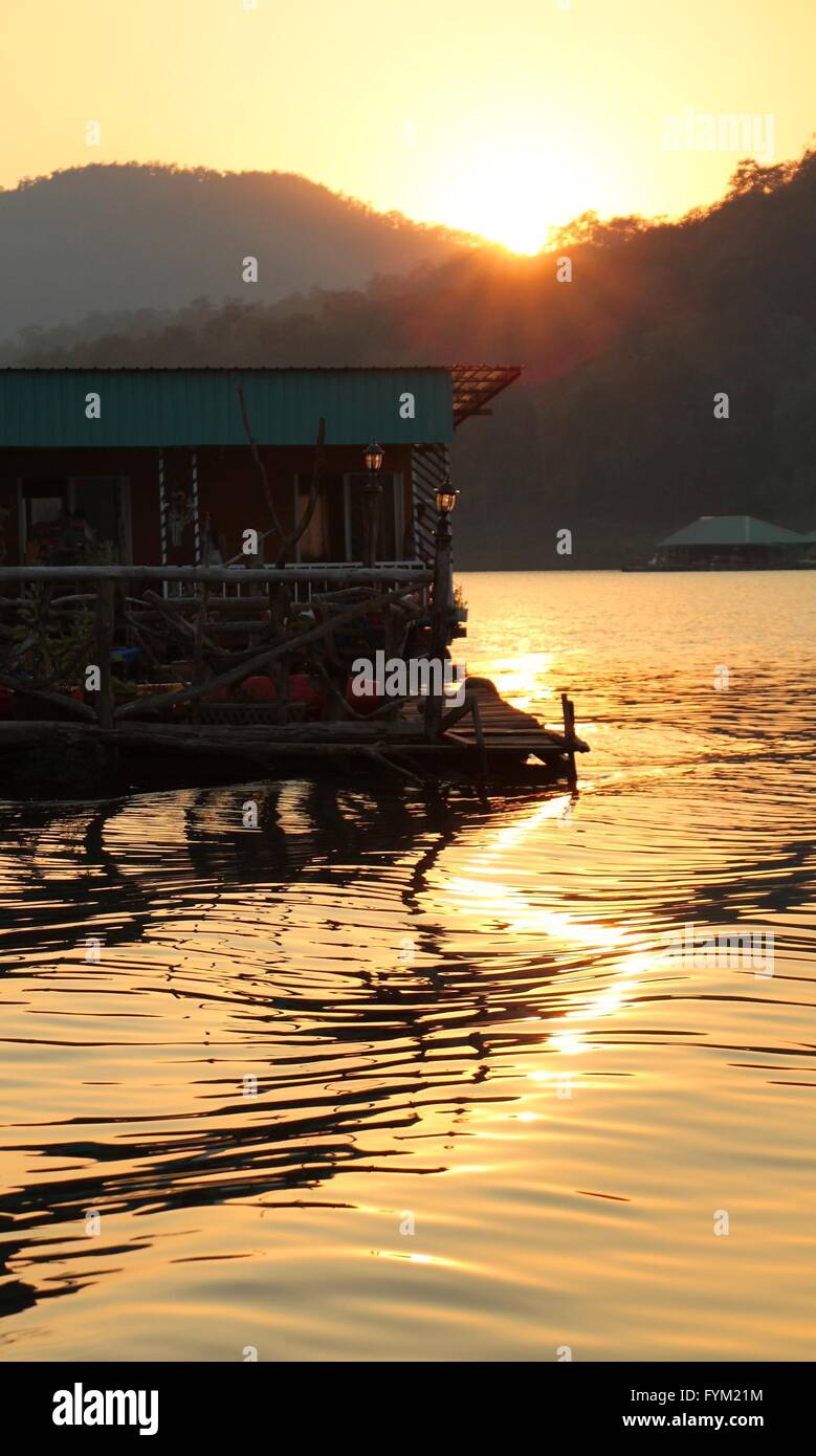 Silhouette di legno casa galleggiante durante il tramonto dorato a Mae Ngad Dam e il serbatoio e Chiang Mai Thailandia Foto Stock