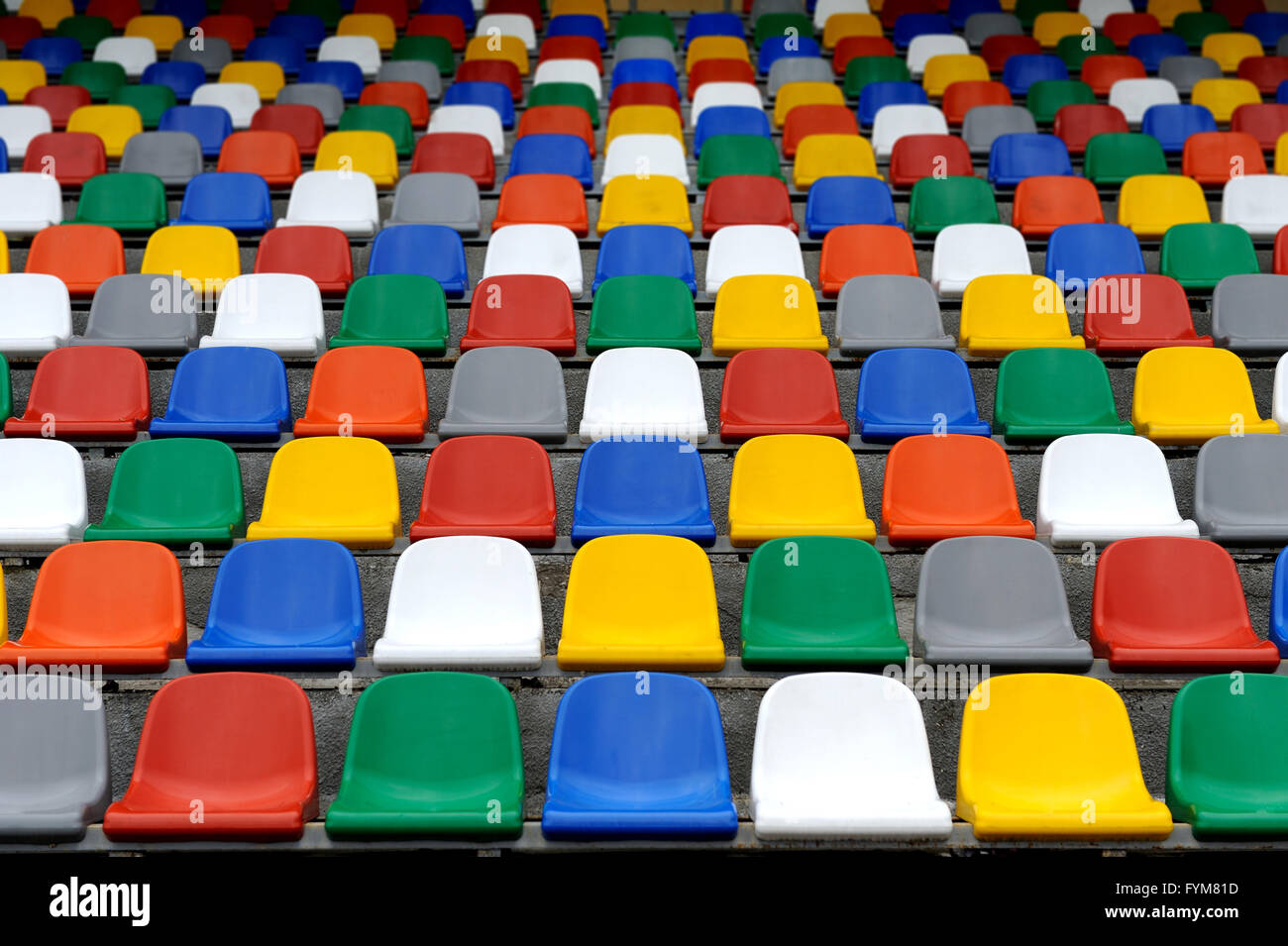 Plastica sedie colorate sorge su stadium Foto Stock